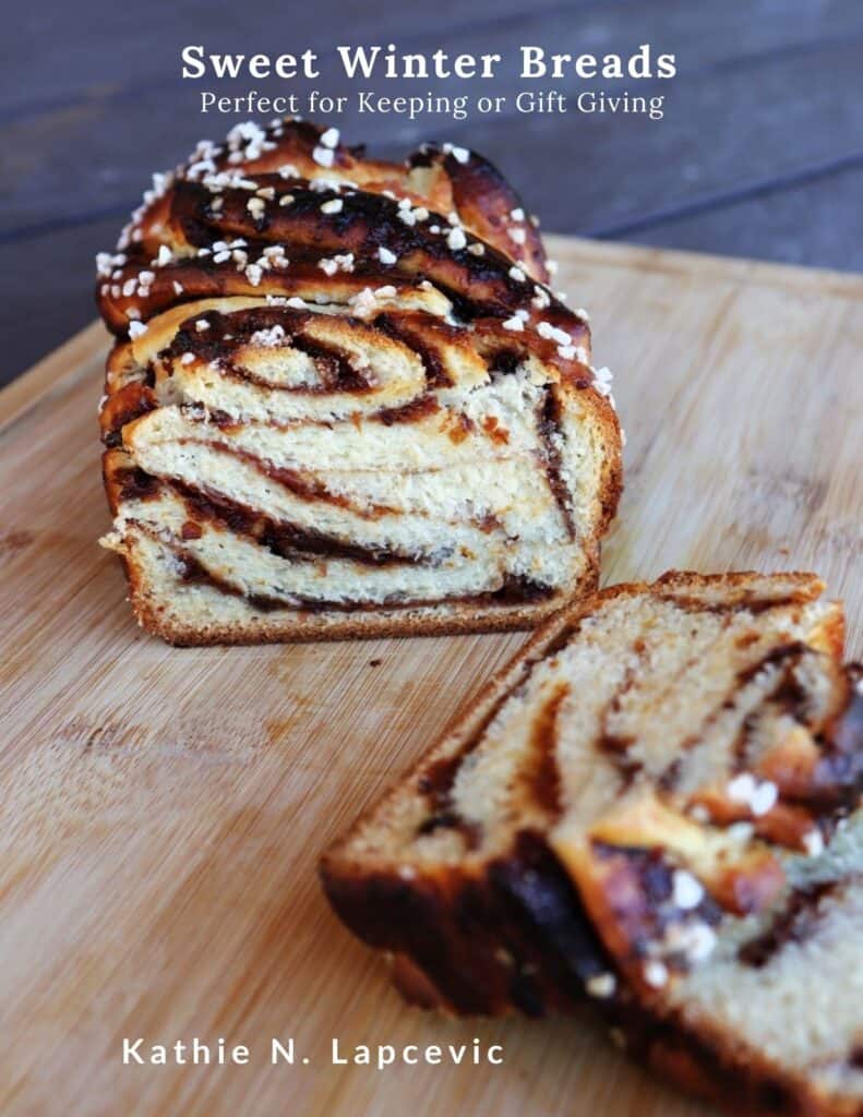 A loaf of jam filled babka with the end sliced off exposing the inside. Text overlay reads: Sweet Winter Breads - Perfect for Keeping or Gift Giving.