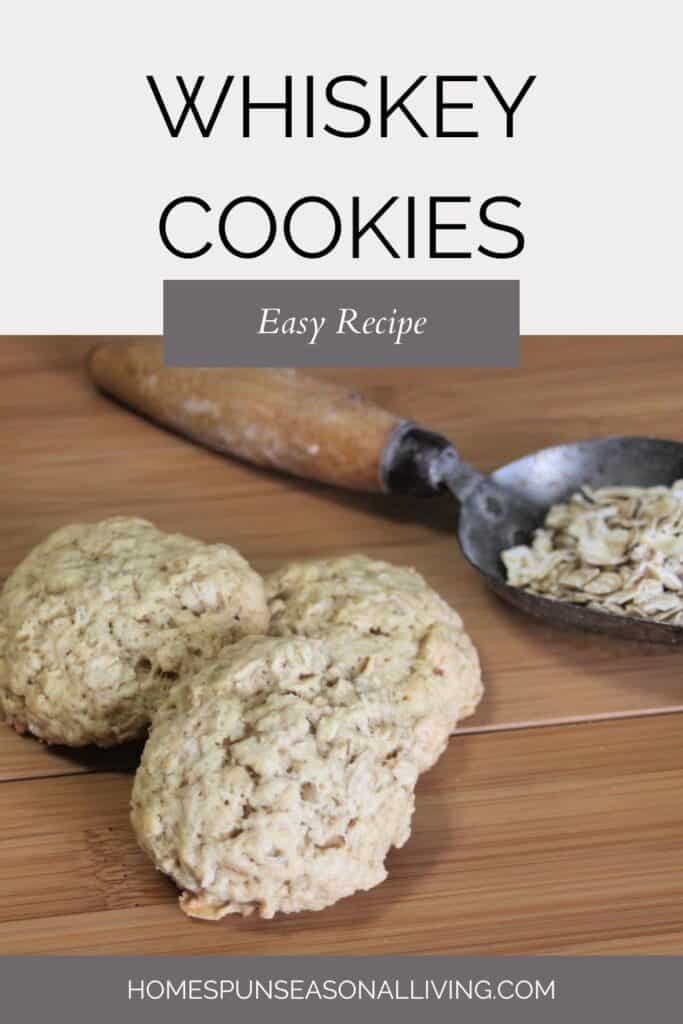Three cookies staggered on a table with a metal scoop full of raw oats in the background. Text overlay reads: Whiskey Cookies: Easy Recipe.
