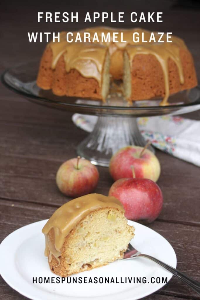 A slice of cake on a plate with a fork. A cake plate with the remaining cake and fresh apples sit in the background. Text overlay reads: Fresh Apple Cake with Caramel Glaze.