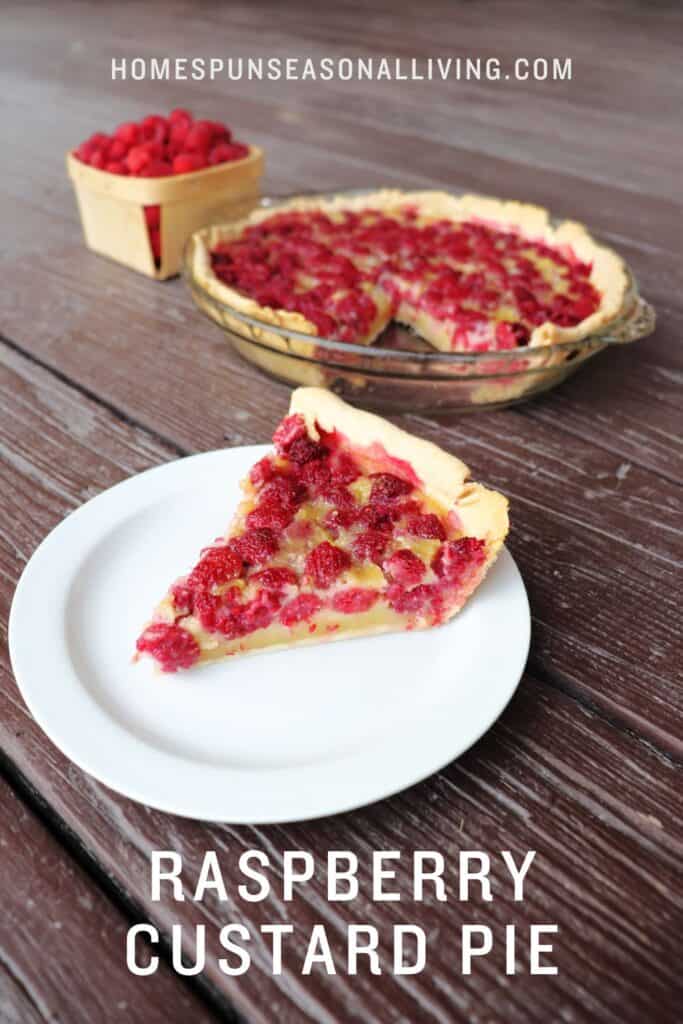 A slice of raspberry custard pie sits on a plate with the remaining pie and a box of raspberries in the background. Text overlay reads: raspberry custard pie. 