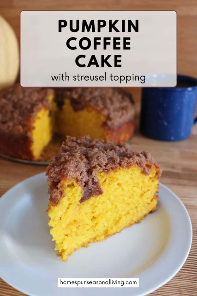 A slice of orange colored cake sits on a white plate with a blue coffee cup and the remaining cake in the background. A text overlay reads: Pumpkin Coffee Cake with streusel topping. 