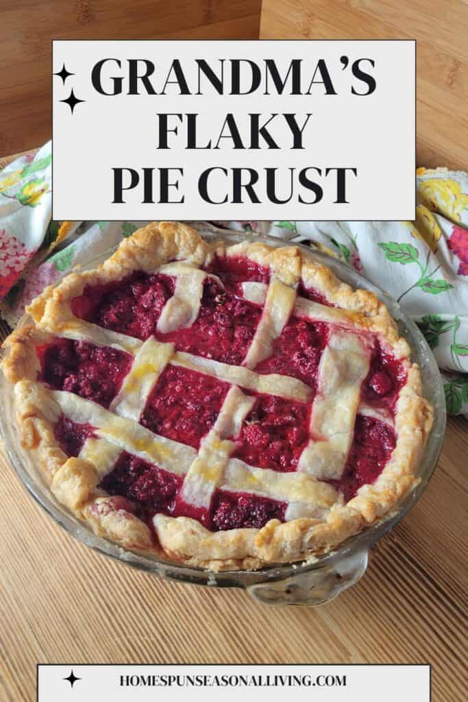A raspberry pie with a lattice top crust sits ona table with a floral cloth behind it. Text overlay reads: Grandma's flaky pie crust.