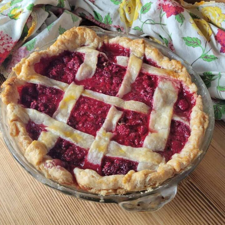 A whole raspberry pie with latice crust top as seen from above.